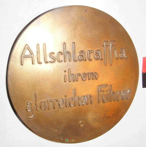 Devast-Medaille, Rückseite: „Allschlaraffia ihrem glorreichen Führer“